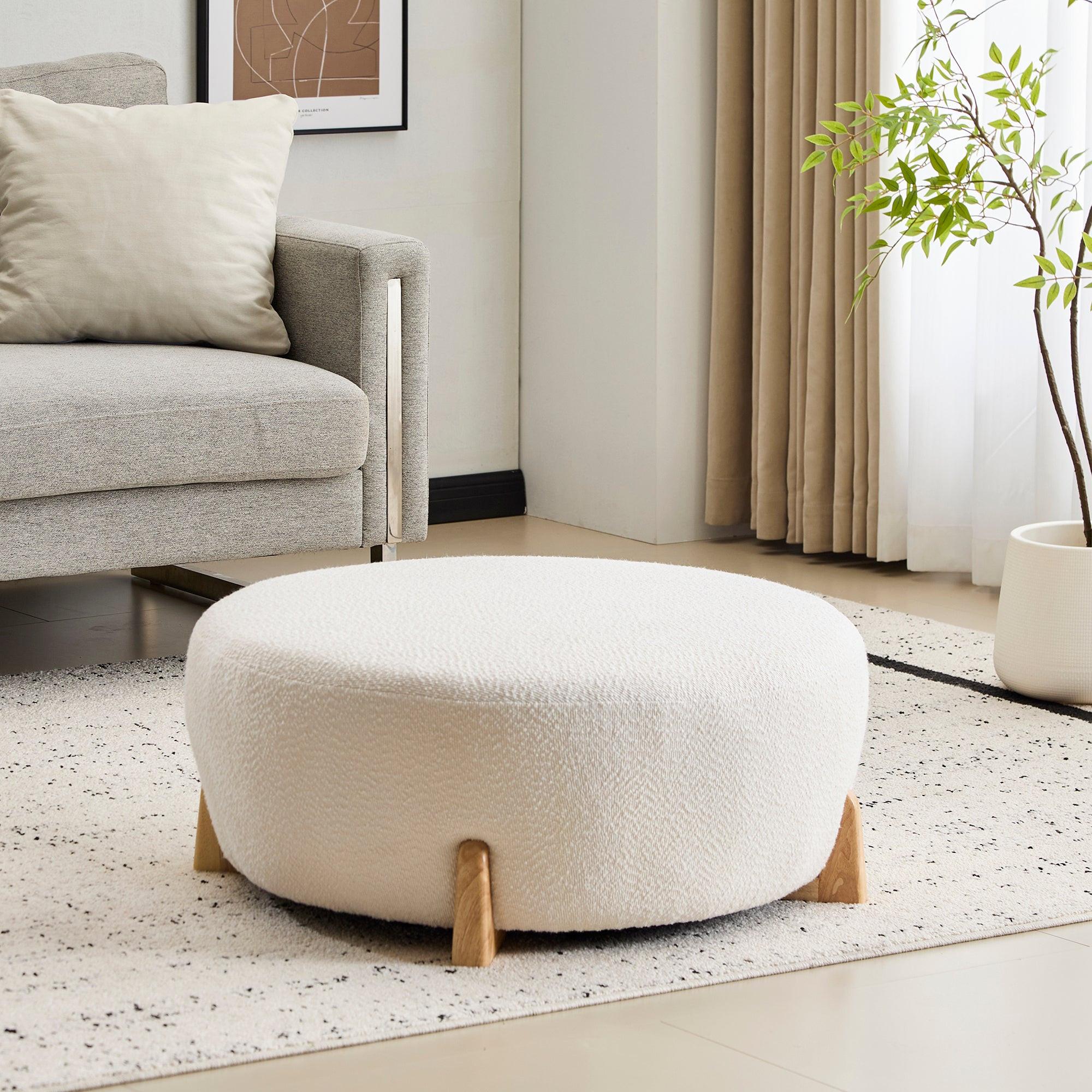 Modish Round Ottoman with Boucle Top and Natural Wood Legs.