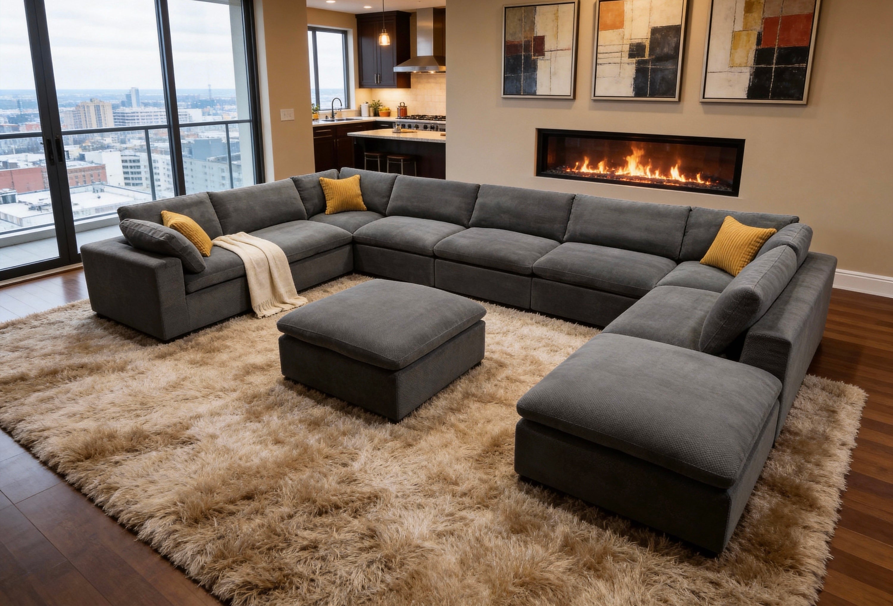 Modern charcoal gray modular sectional sofa with matching ottoman and mustard yellow toss pillows on a shaggy rug.