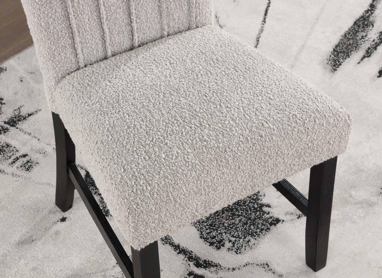 Detailed view of boucle fabric texture and cushioned seat on dining chair from the Genuine Marble Dining Table Set.