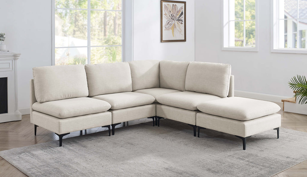 Beige linen upholstered modular sectional sofa with plush cushions and modern black metal legs in a bright living room.