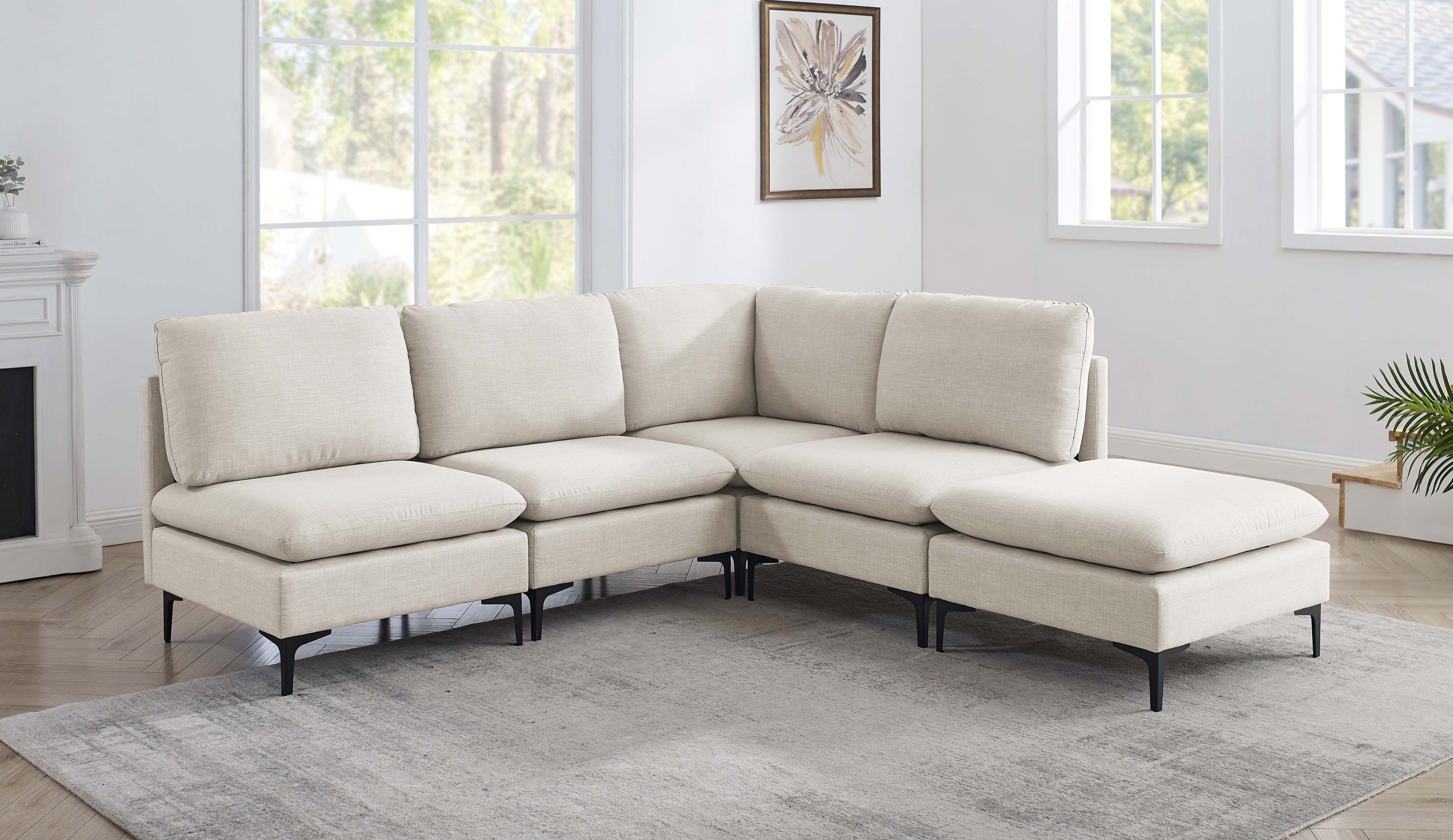 Beige linen upholstered modular sectional sofa with plush cushions and modern black metal legs in a bright living room.