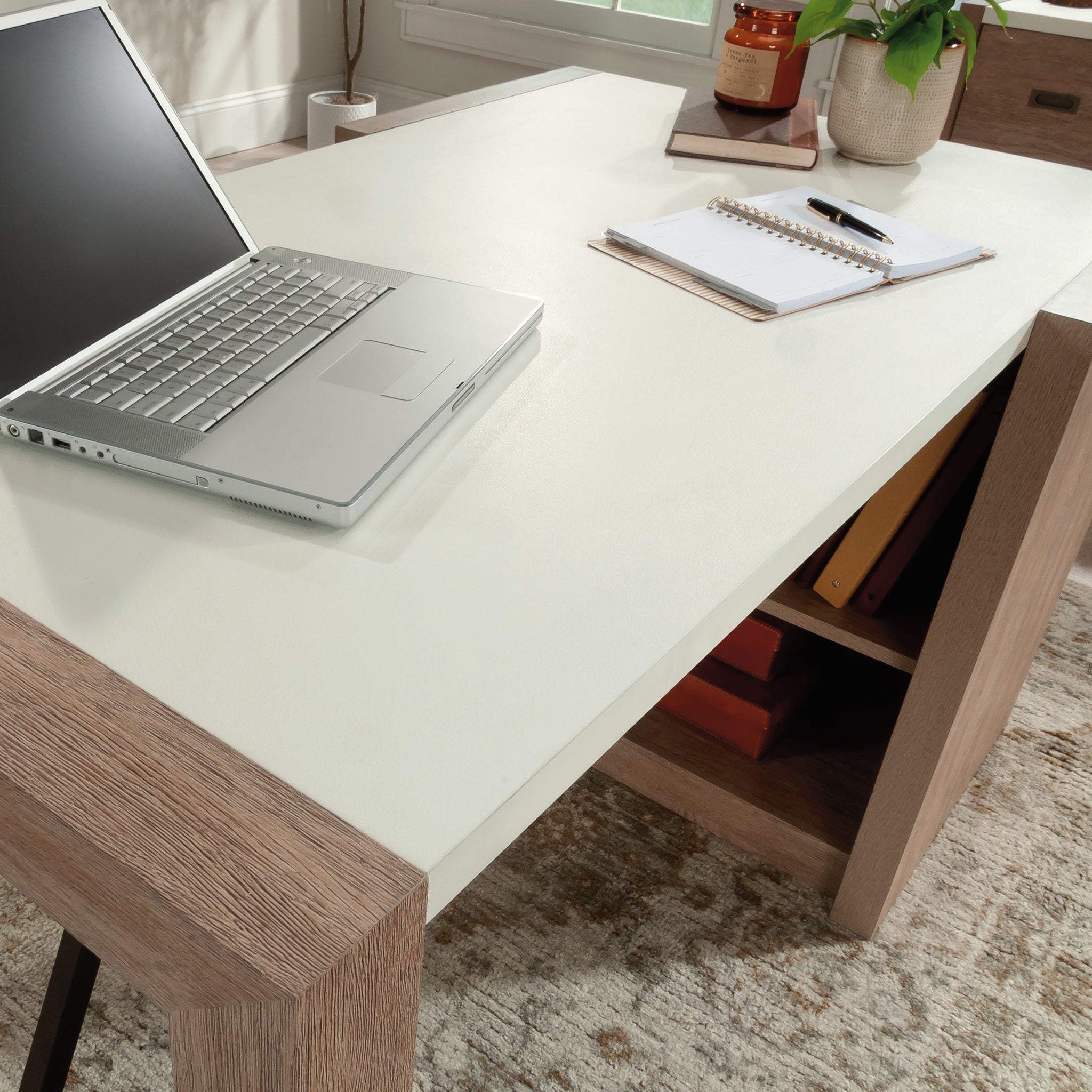 Top view of brown finish desk with white surface, laptop, and office supplies, ideal for modern farmhouse home office setup.