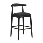 Angled view of black fabric bar stool with curved wooden back and cushioned seat, blending comfort and modern style.