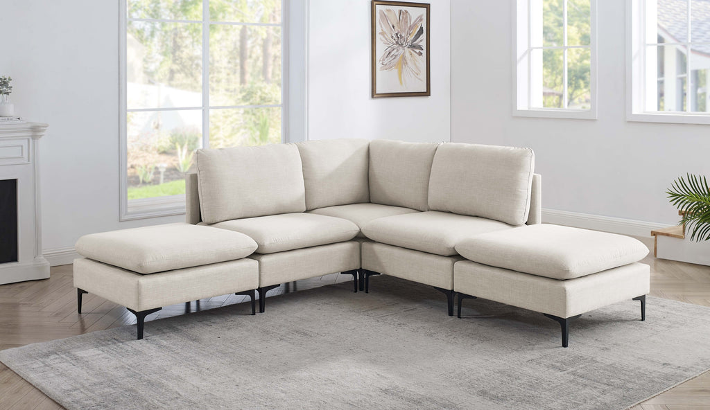 Beige linen modular sectional sofa with plush cushions and modern black metal legs in a bright, contemporary living room.