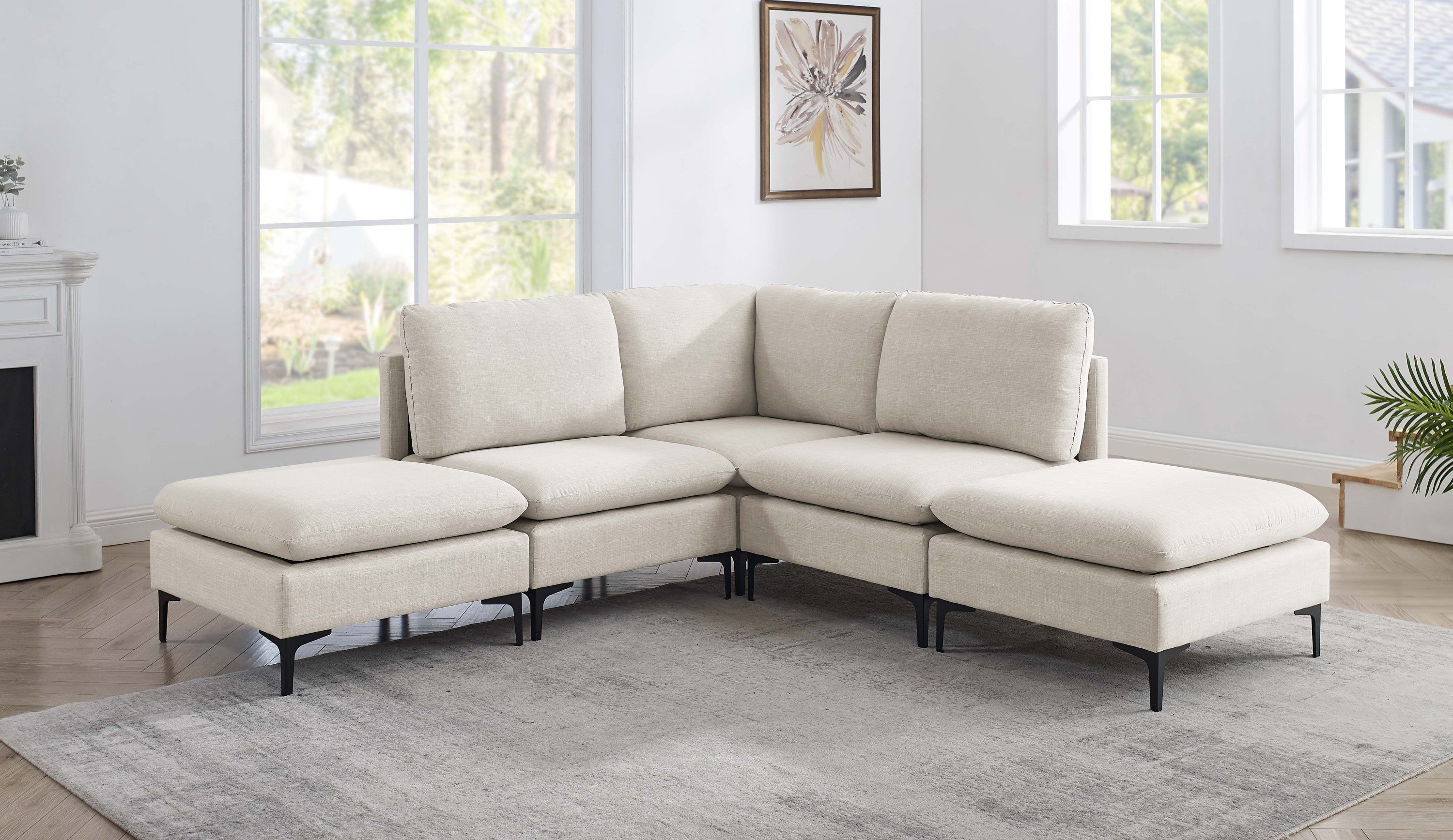 Beige linen modular sectional sofa with plush cushions and modern black metal legs in a bright, contemporary living room.
