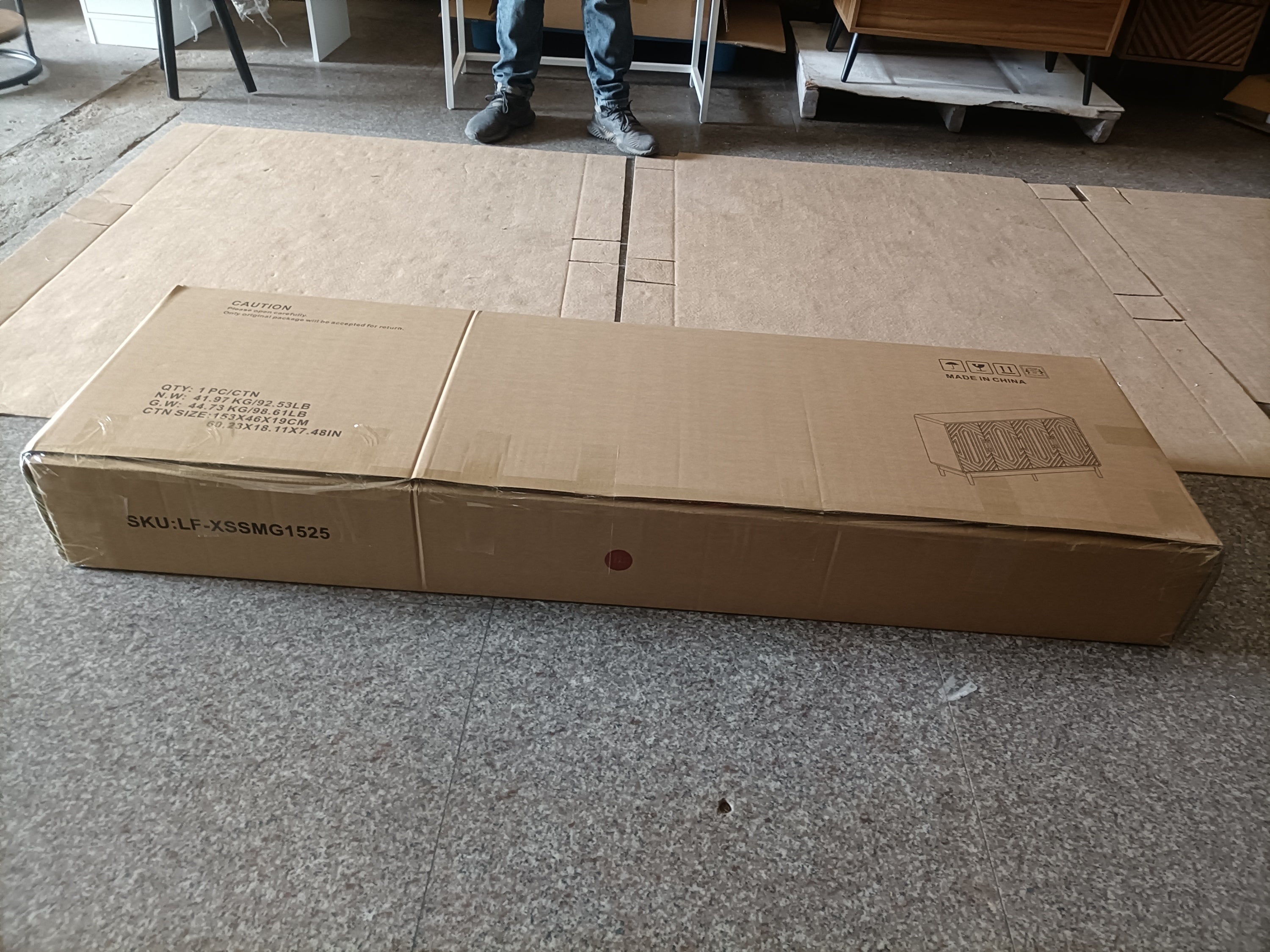 Flat-packed walnut sideboard in shipping box labeled with SKU and product image. Ready for easy assembly and delivery.