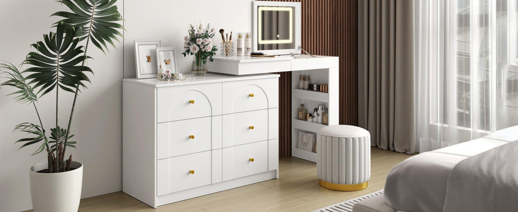 Stylish vanity desk with mirror and lights in bright bedroom, featuring flip-top makeup table and gold-accented drawers.