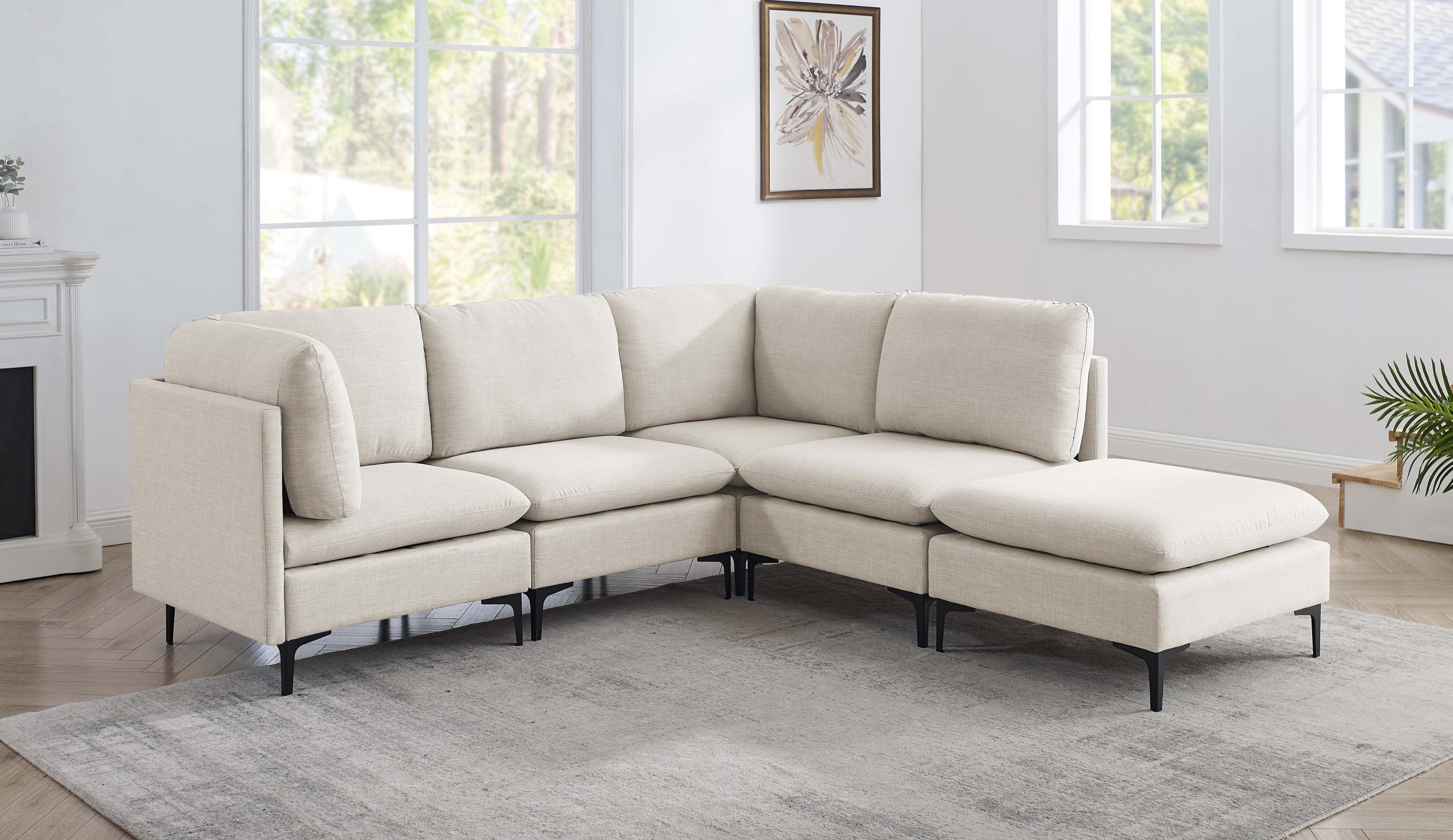 Beige linen modular sectional sofa with plush cushions and sleek black metal legs in a bright, modern living room.