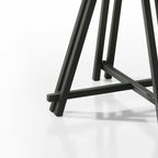 Detailed view of the black metal base of the Round Oak Dining Table, emphasizing its sturdy geometric design.