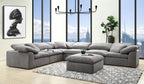 Modern gray linen modular sectional sofa with deep, plush seating and matching ottoman on a patterned area rug.