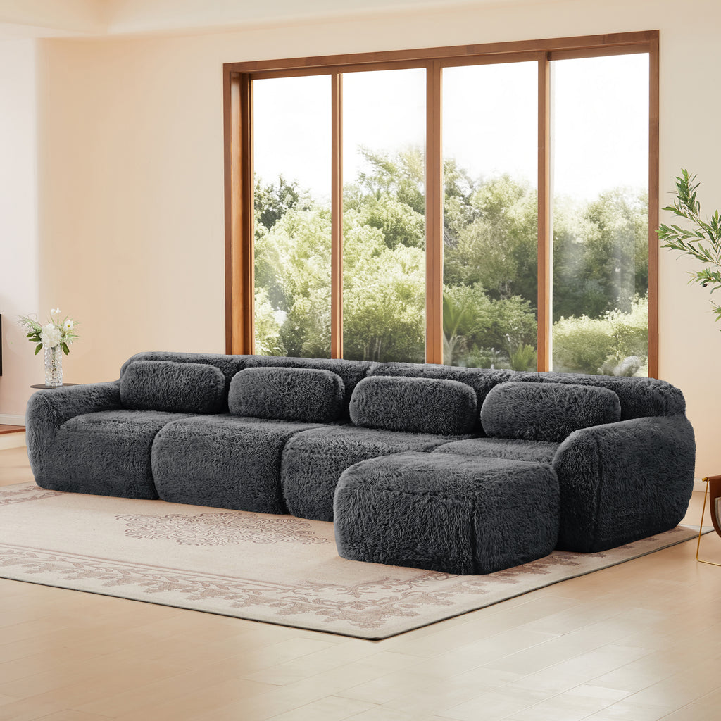 Dark grey sofa in modular sectional layout with plush upholstery and ergonomic cushions, offering flexible arrangement options.