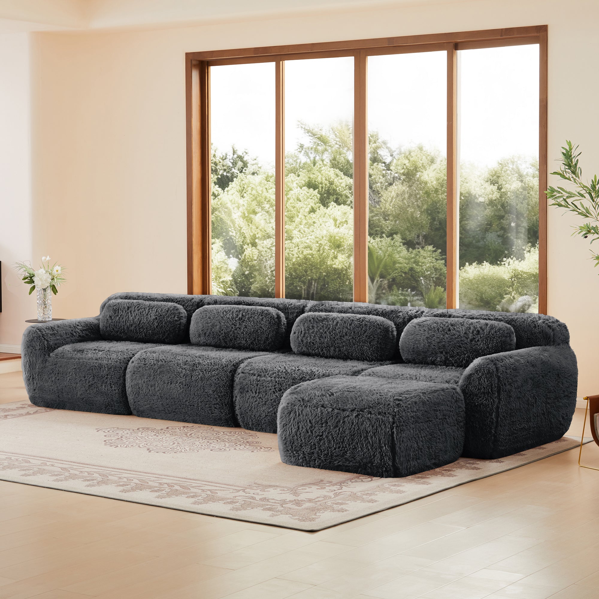 Dark grey sofa in modular sectional layout with plush upholstery and ergonomic cushions, offering flexible arrangement options.