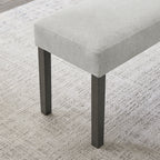 Detail of Selena Dining Set bench with textured light gray fabric and sturdy black legs, designed for modern dining areas.