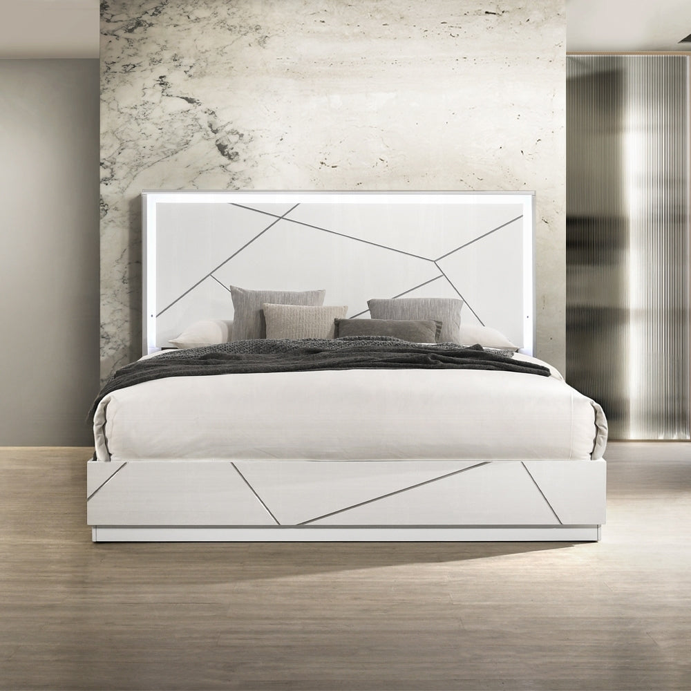 Modern white LED queen bed with geometric panel design and ambient headboard lighting, styled in a contemporary bedroom setting.
