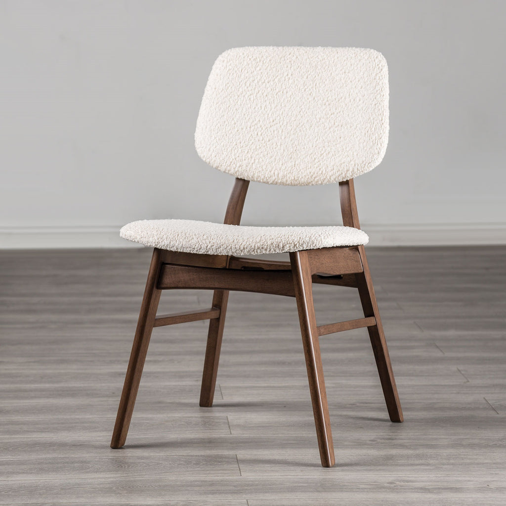Elegant mid-century dining chair with angled walnut legs and soft beige padding, suitable for stylish dining room setups.