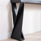 Side view of modern black console table's unique crossed leg base, emphasizing its geometric and modern style.