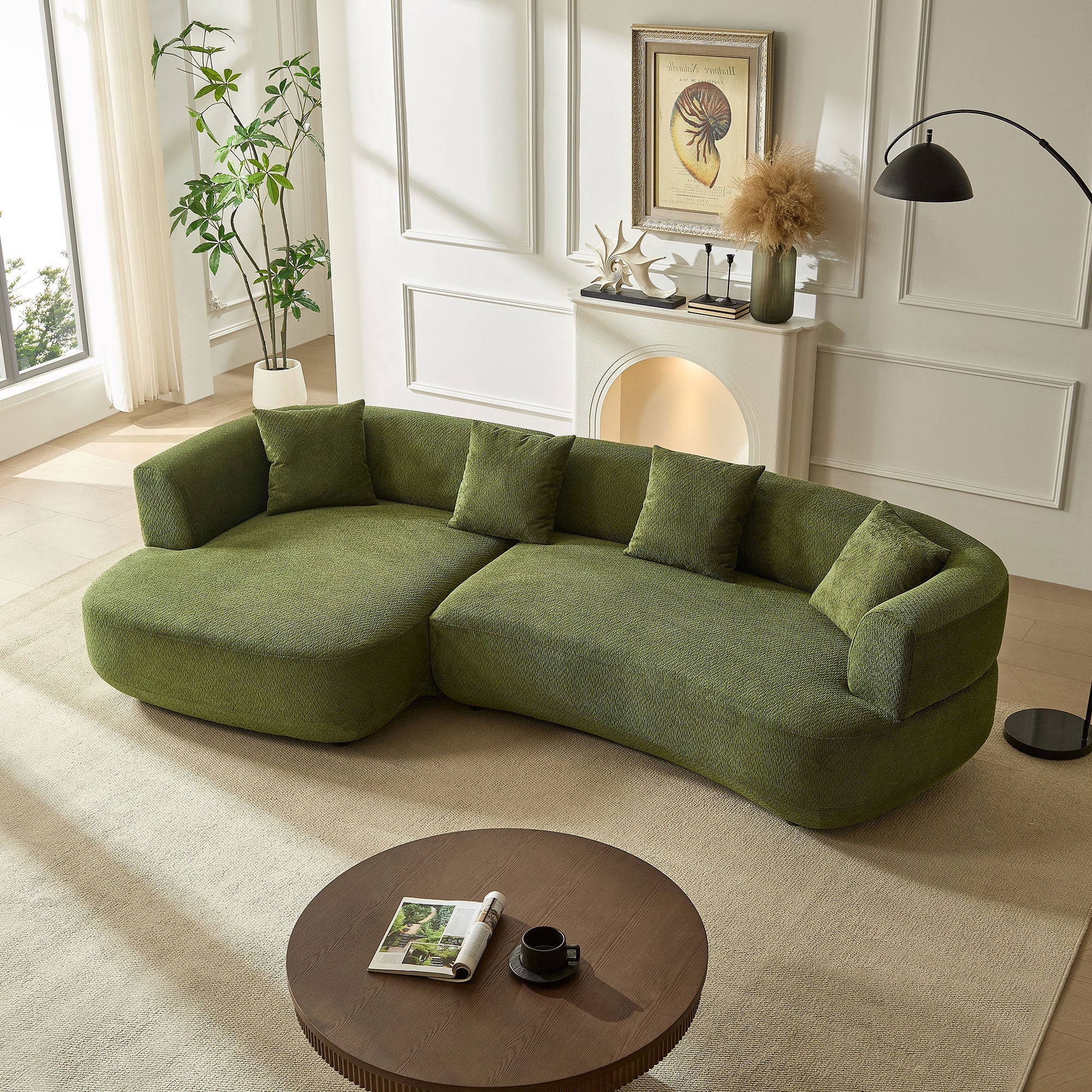 Modern 4-seat curved green sectional sofa in textured fabric with four matching throw pillows, set in a bright room.