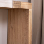 Close-up of leg on modern console table with chevron top, showing natural wood grain and smooth finish.