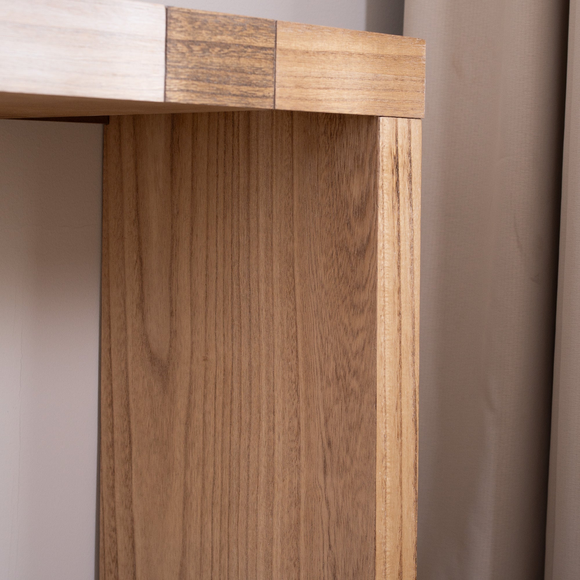 Close-up of leg on modern console table with chevron top, showing natural wood grain and smooth finish.