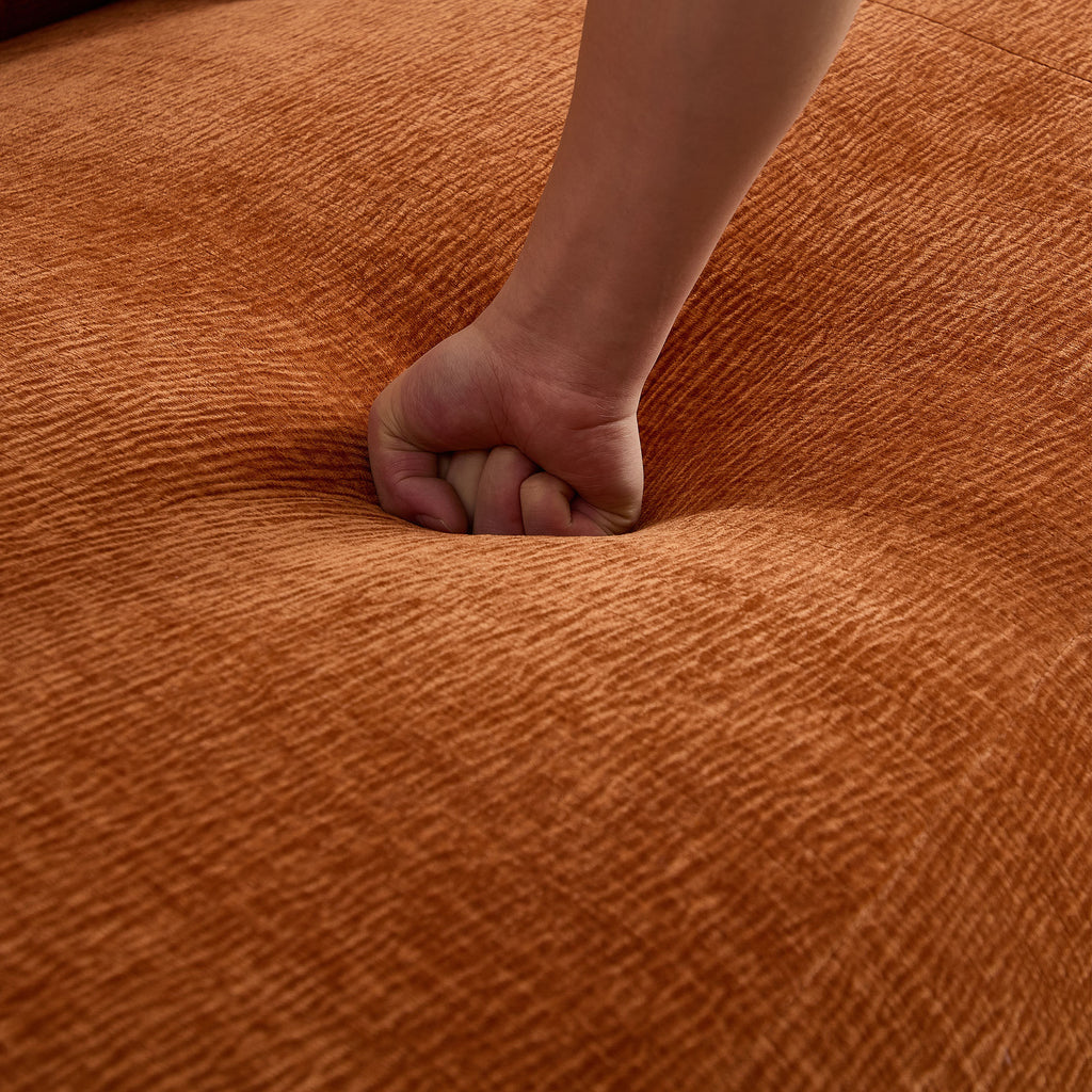 Hand pressing into the seat of the Oversized L-Shape Sofa, emphasizing the deep cushioning and soft, textured fabric.