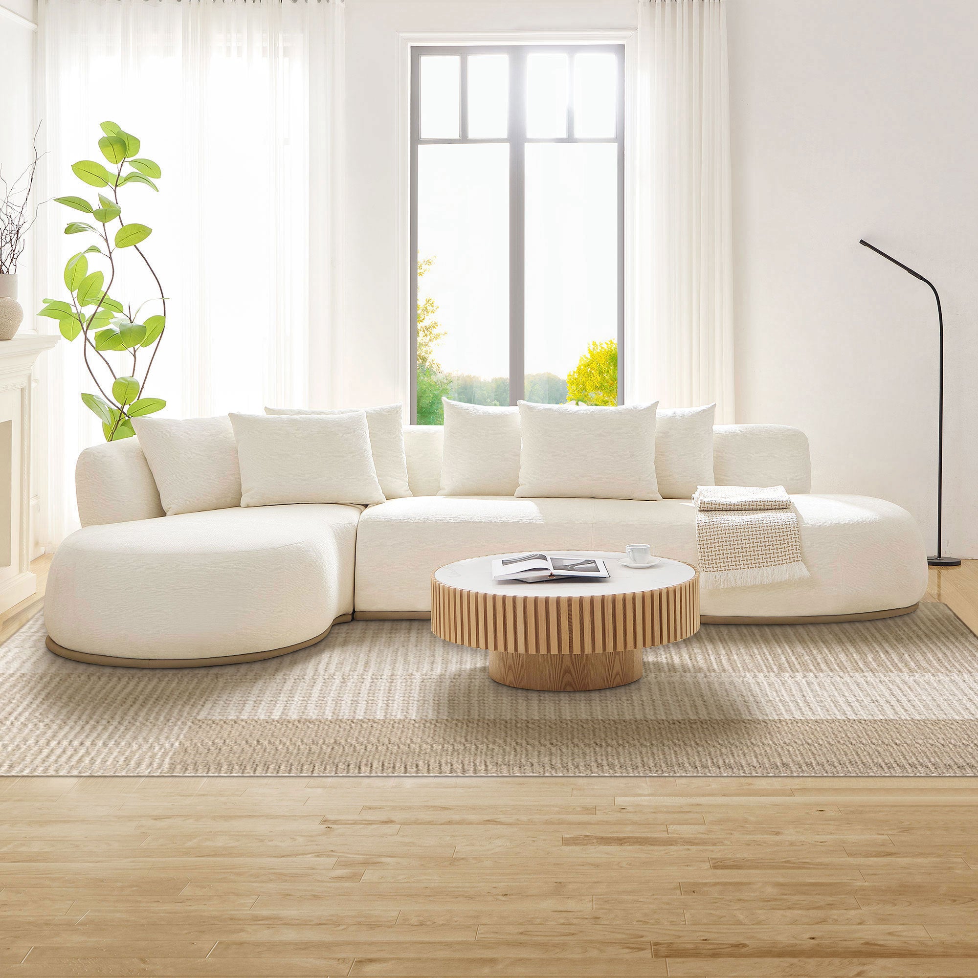 Modern beige L-shape sectional sofa with ottoman placed in a sunlit living room, showcasing its elegant curves and medium-soft seating.