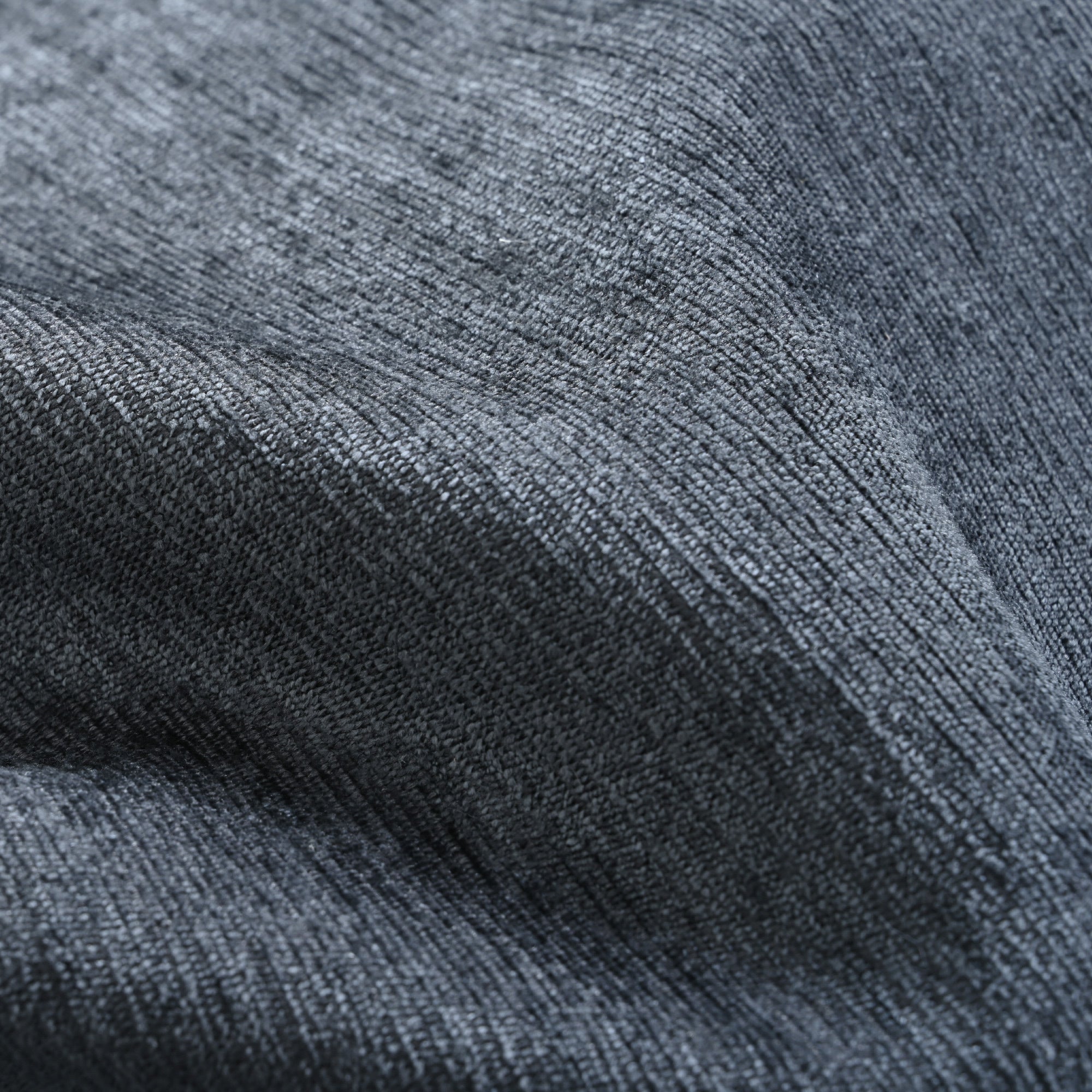 Close-up texture of dark grey upholstery fabric on modular sofa, showcasing soft, durable material ideal for everyday comfort.