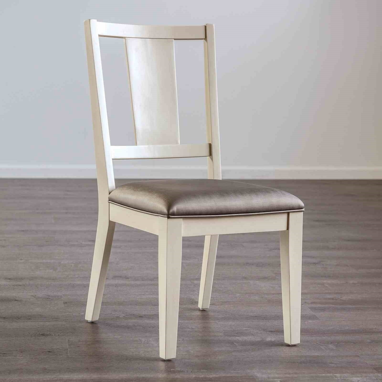 Transitional dining chair with oak finish, padded seat, and faceted backrest shown on wood flooring. Ideal for modern dining rooms.