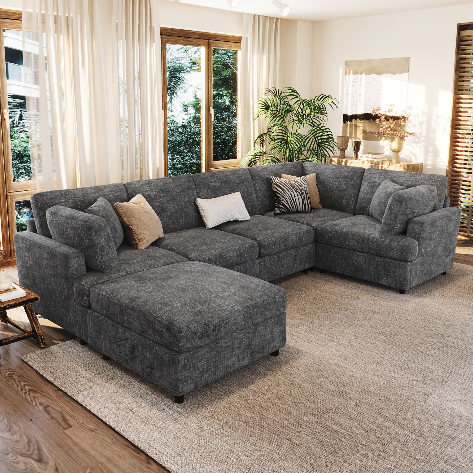 Convertible U-Shaped Sectional Sofa with Ottoman in dark gray chenille, shown in a bright living room with wood flooring and large windows.