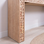 Side panel detail of rustic console table with vertical log slice inlays, showcasing natural wood tones and texture.