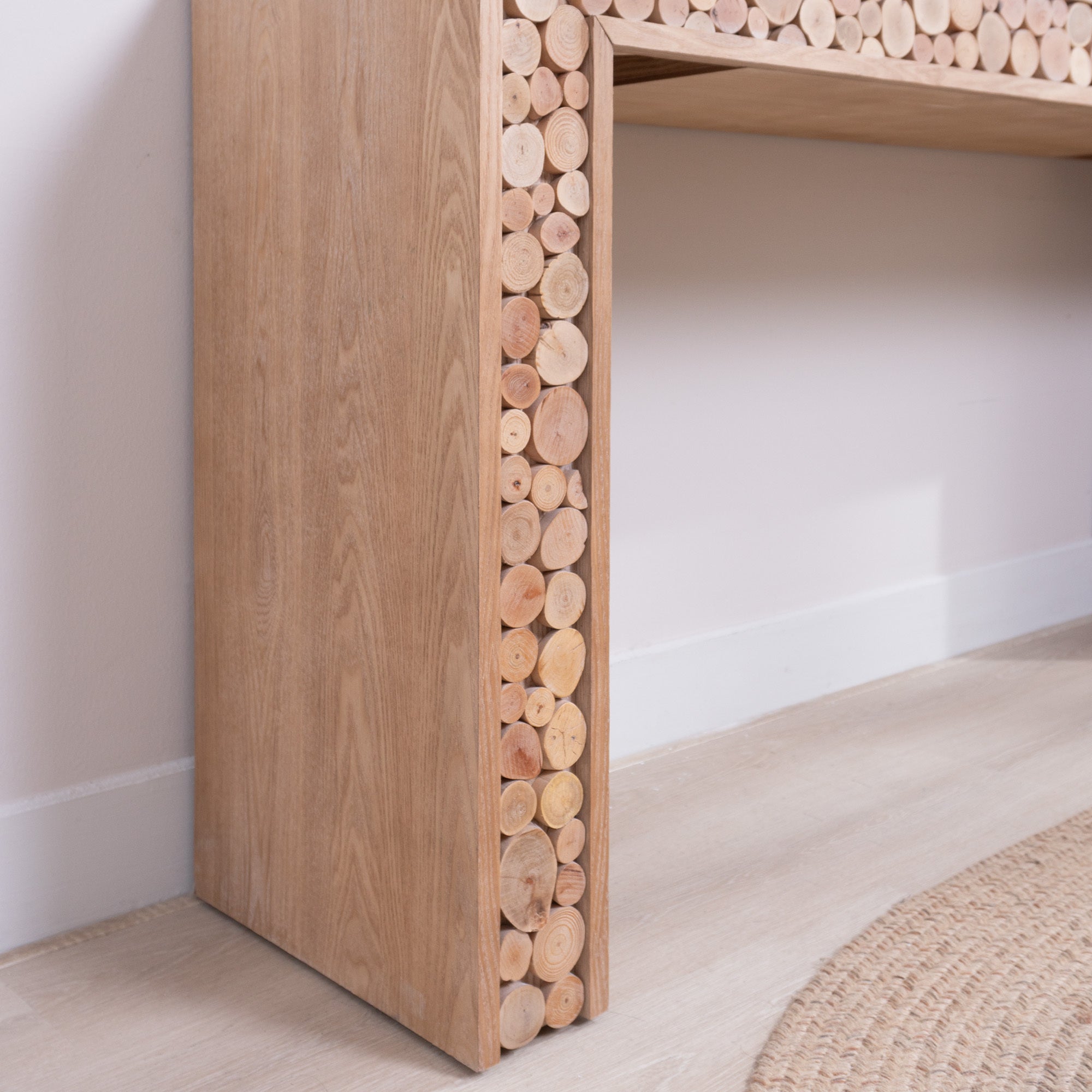 Side panel detail of rustic console table with vertical log slice inlays, showcasing natural wood tones and texture.
