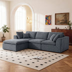 Modern L-shaped sofa with chaise in dark blue chenille fabric, set in a bright living room with wood flooring and minimalist decor.