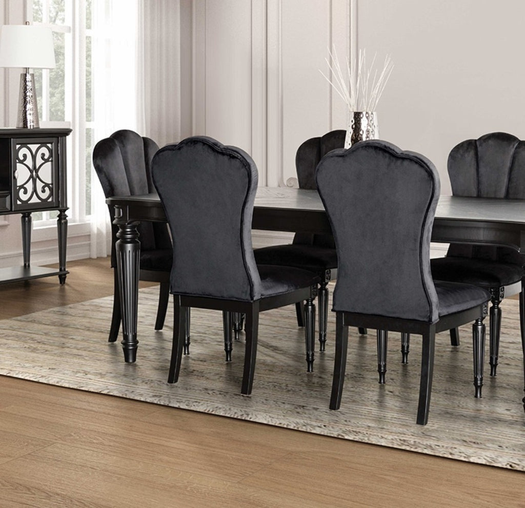Set of black dining room side chairs with fluted legs and upholstered backs placed around a rectangular dining table.