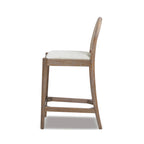 Side profile of Panama 26.5' Rattan Counter Stool with arched cane back and padded seat, highlighting its sleek silhouette and durable wood frame.