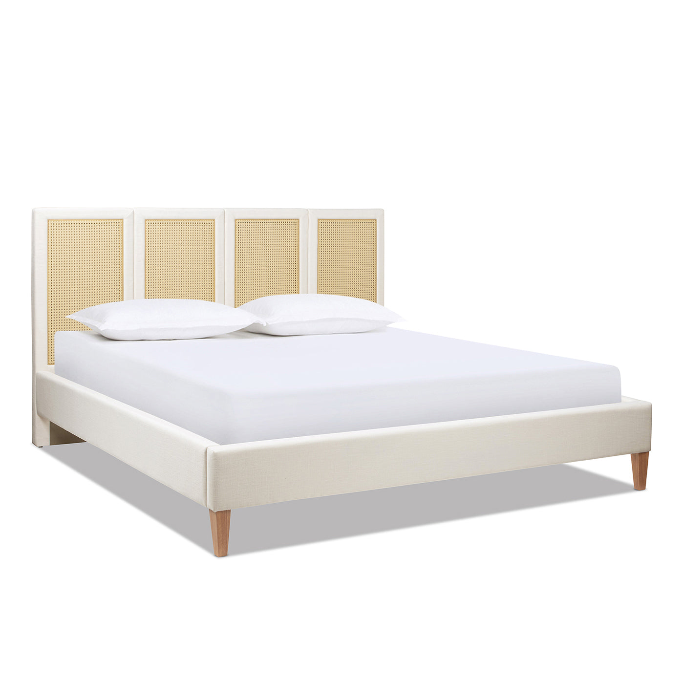 Toscana King Upholstered Cane Bed shown without bedding, highlighting its antique white polyester frame and rattan headboard panels.