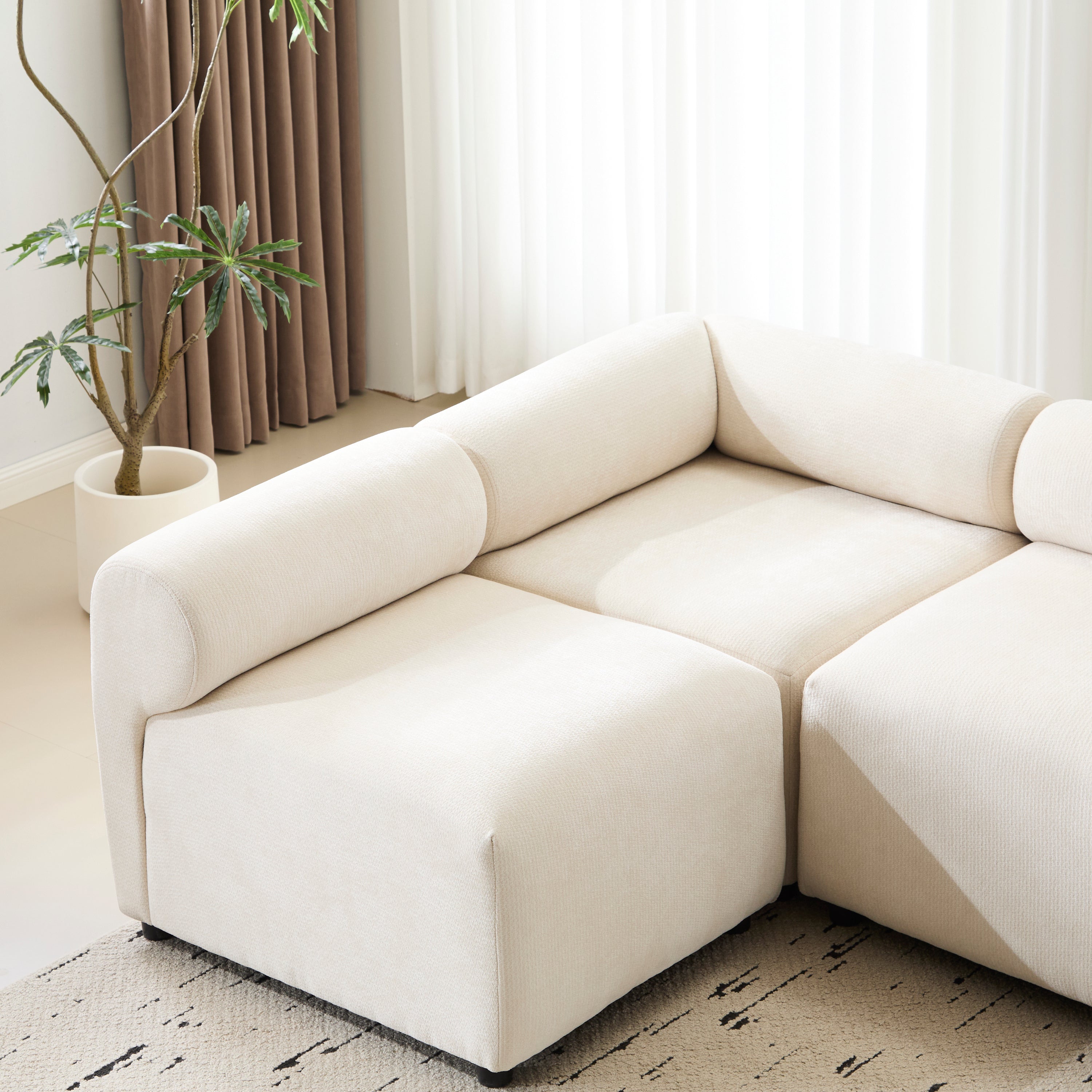 Left corner seat of the Evelyn modular L shaped chenille sofa, highlighting its curved armrest and plush seating.