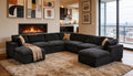 Dark charcoal modular sectional sofa in a modern living room with a fireplace, cream throw, and tan toss pillows.