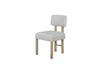 Angled view of upholstered dining chair set with soft fabric seat and backrest, supported by a natural oak wood frame.