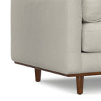 Close-up of wooden leg and lower frame on Modern Armchair Cream White - Morrison Collection, emphasizing mid-century design.