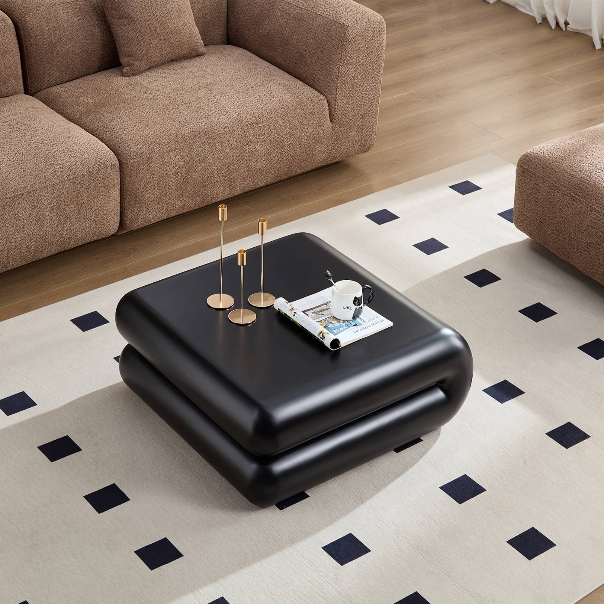 Top view of black fiberglass coffee table with rounded edges, styled with candles and magazines, enhancing modern living room decor.