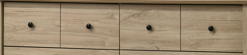 Upper drawers of Elara Light Oak Dresser with round black knobs, offering sleek modern storage design.