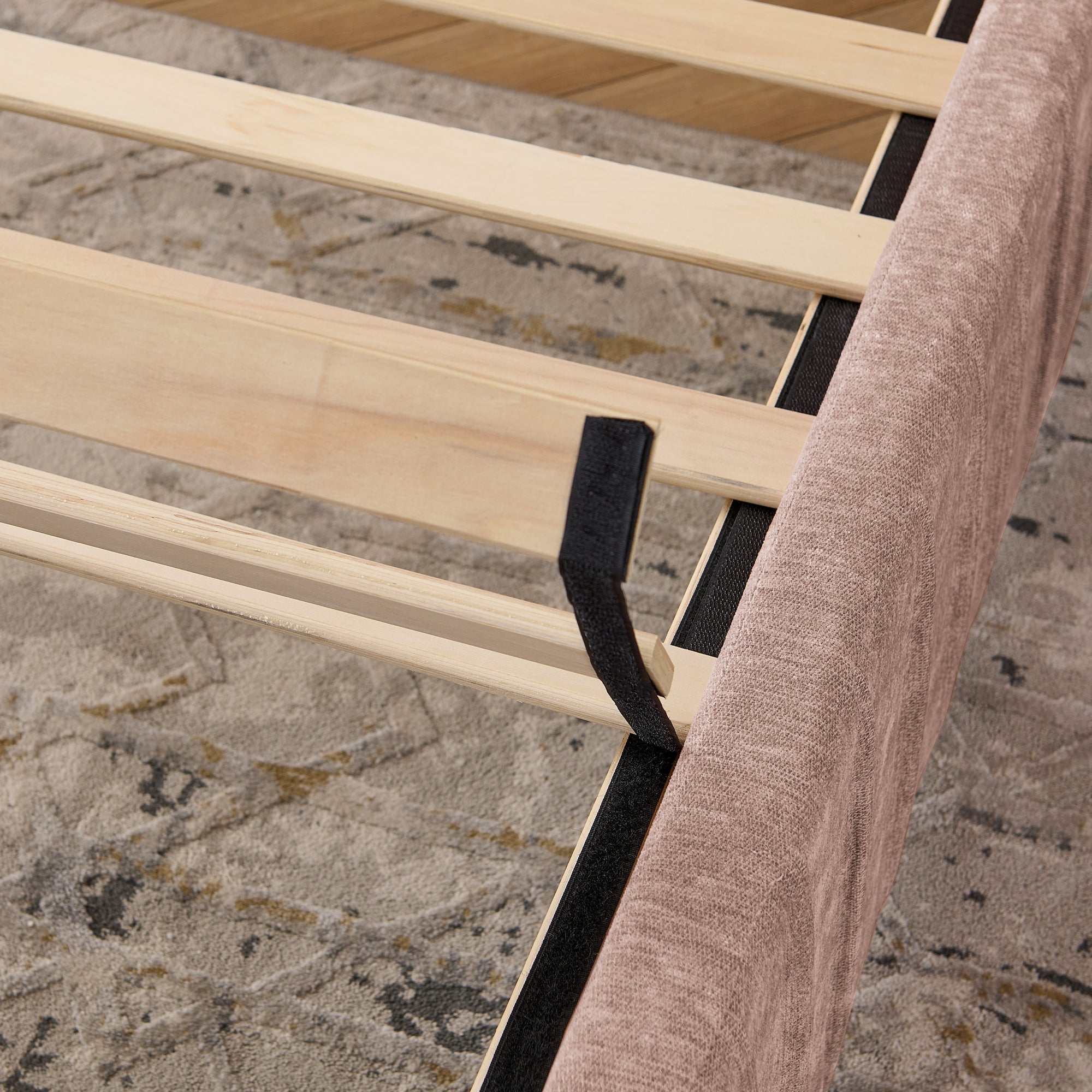 Wooden slat support system of queen upholstered bed frame, ensuring mattress stability without the need for a box spring.