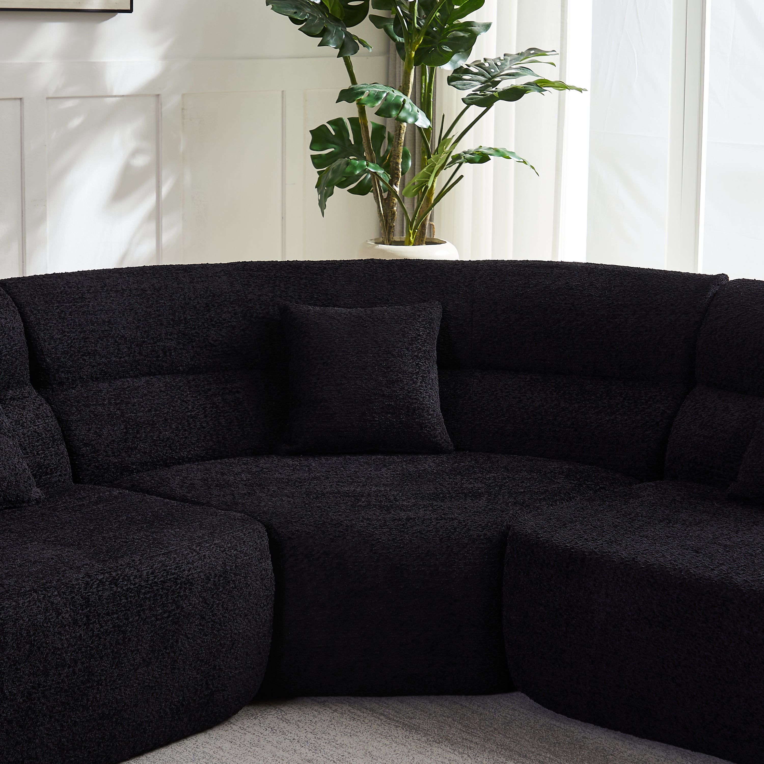 Modern Black Modular Sofa - Luxury Chenille 4-Seater with curved 123.2-inch design, plush backrest and pillow in a bright living room.