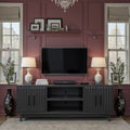 Radiance TV Stand 85 inch TVs - Black Finish styled in a modern living room with wall-mounted TV, lamps, and decorative accents.