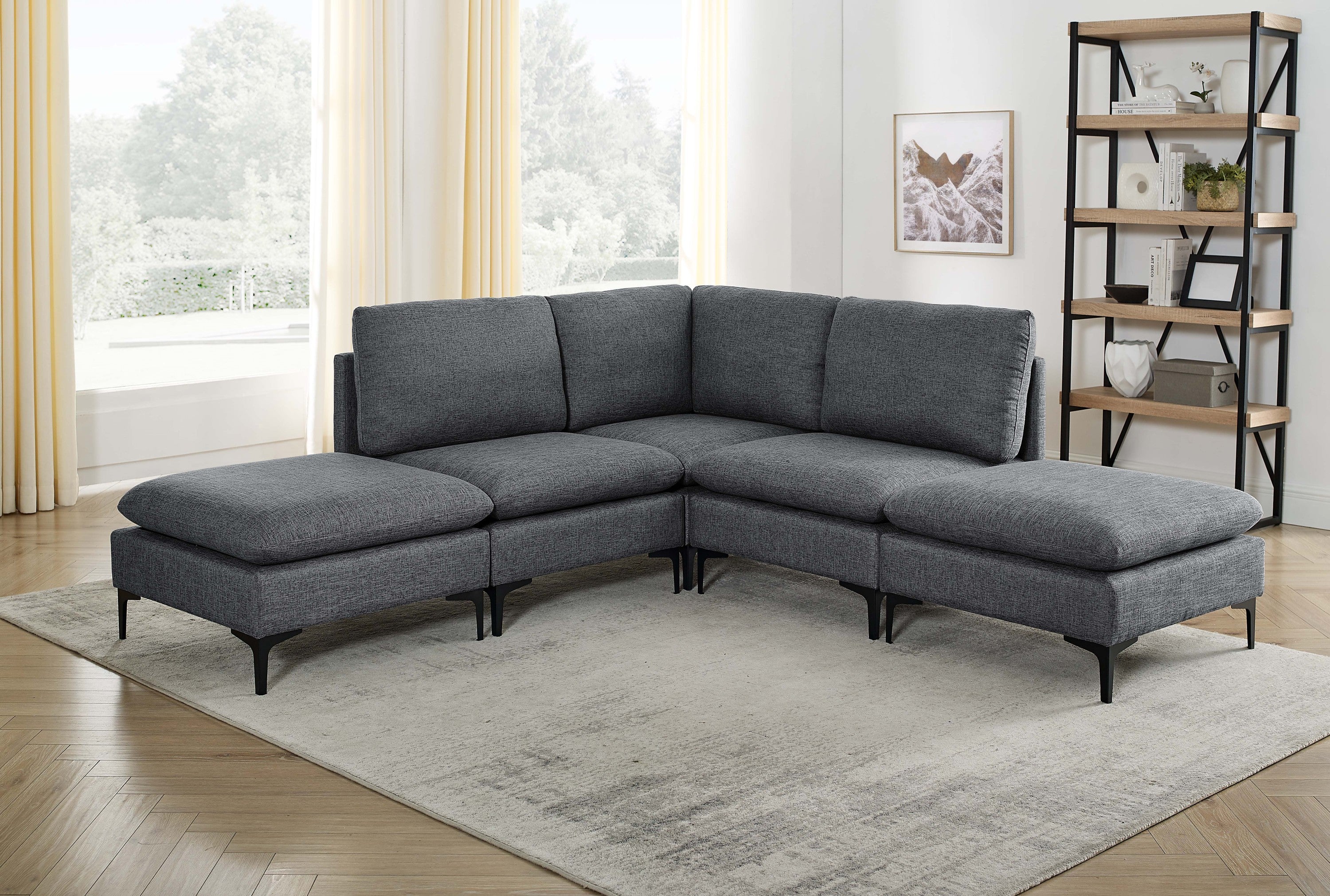 Dark gray linen upholstered modular sectional sofa with black metal legs in a sunlit living room.