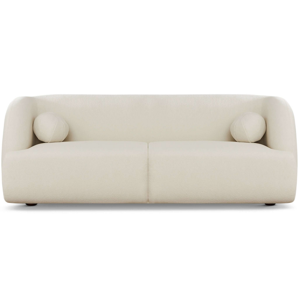 Modern white boucle sofa with curved silhouette, two round bolster pillows, and subtle wood legs.