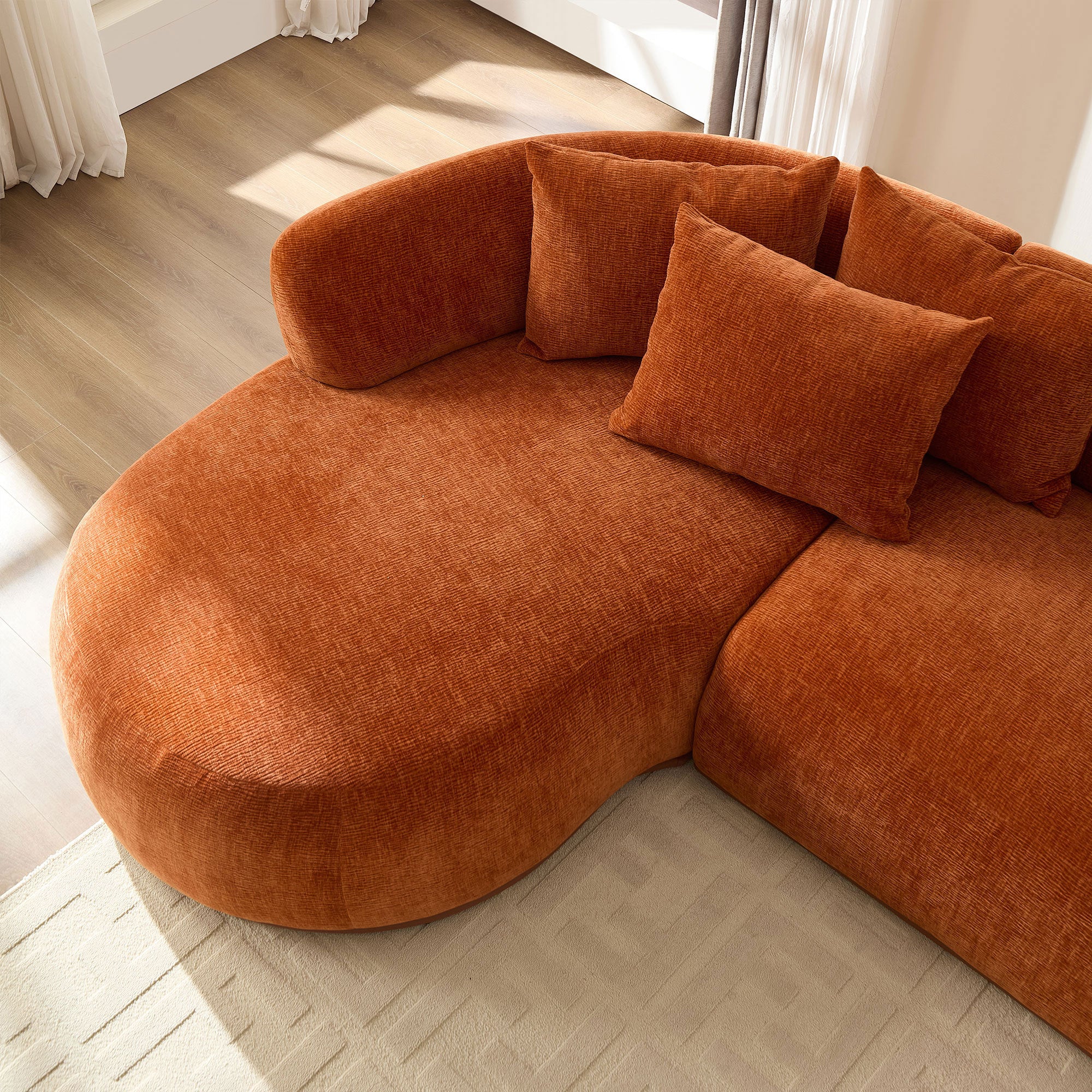 Curved chaise detail of modern L-shape sectional sofa with deep seat and plush cushions, ideal for lounging in stylish interiors.