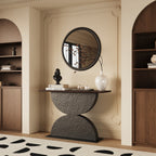 Modern console table with a wooden top and sculptural dark gray base featuring two hammered-texture semi-circles.