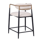 Rear angled view of a counter height chair with a curved gold metal backrest and black legs, upholstered in beige fabric.