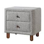 Grey boucle upholstered nightstand featuring two drawers with dark wooden knobs on short, rounded wooden legs.