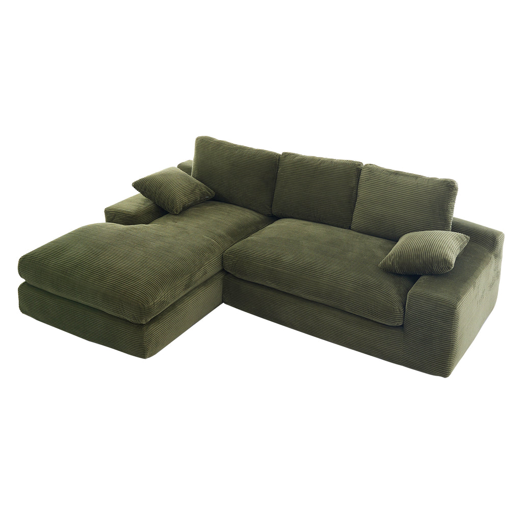 Top view of green corduroy sofa with chaise, cushions, and pillows, showcasing its soft texture and spacious seating area.